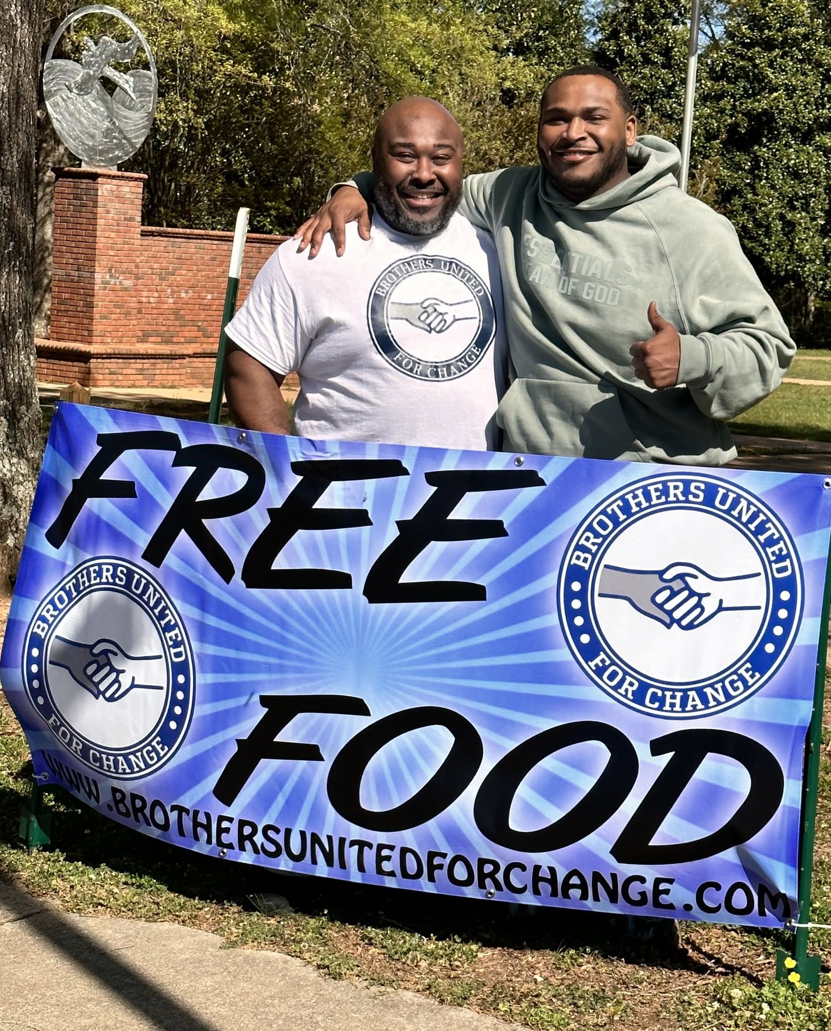 BUFC brothers holding Free Food banner at community event