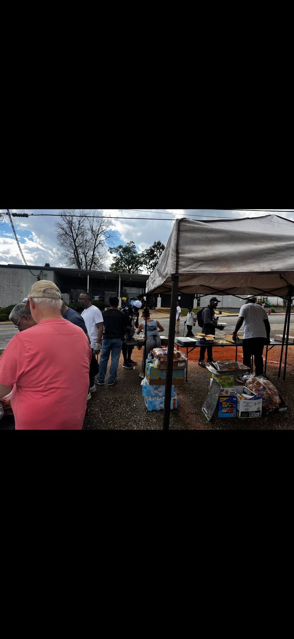BUFC brothers under tent serving meals to the community